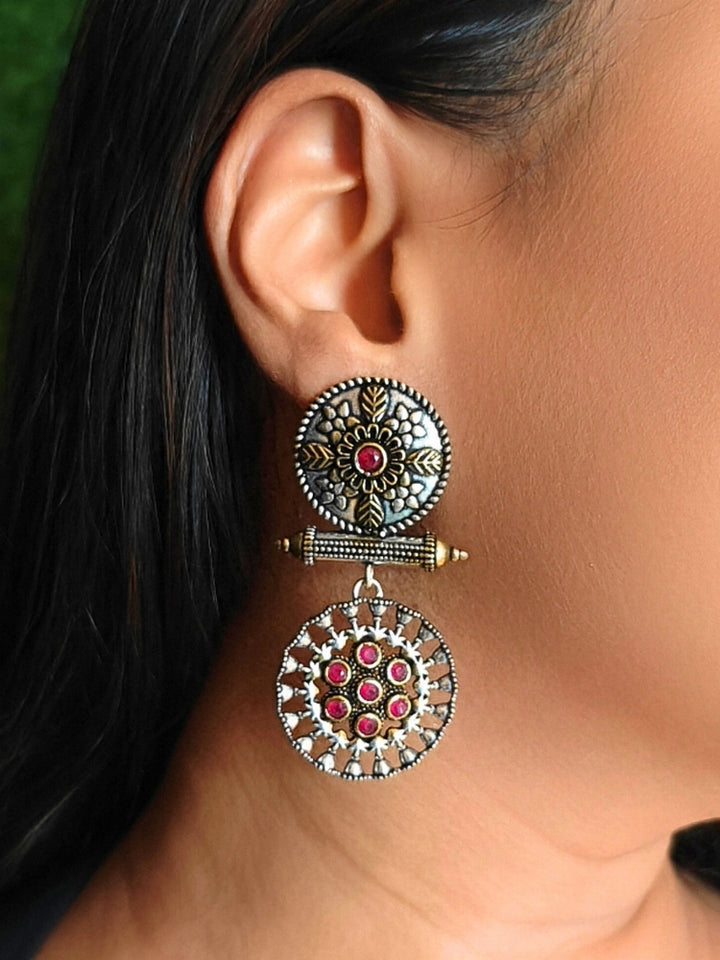 Close-up of a woman wearing an ornate traditional (Dual Tone Polish) Red Oxidised Earrings set with Kundan. Festive celebration look enhanced with sparkling artificial Oxidised Earrings. Saree look completed with elegant artificial Earrings set for festive occasions.