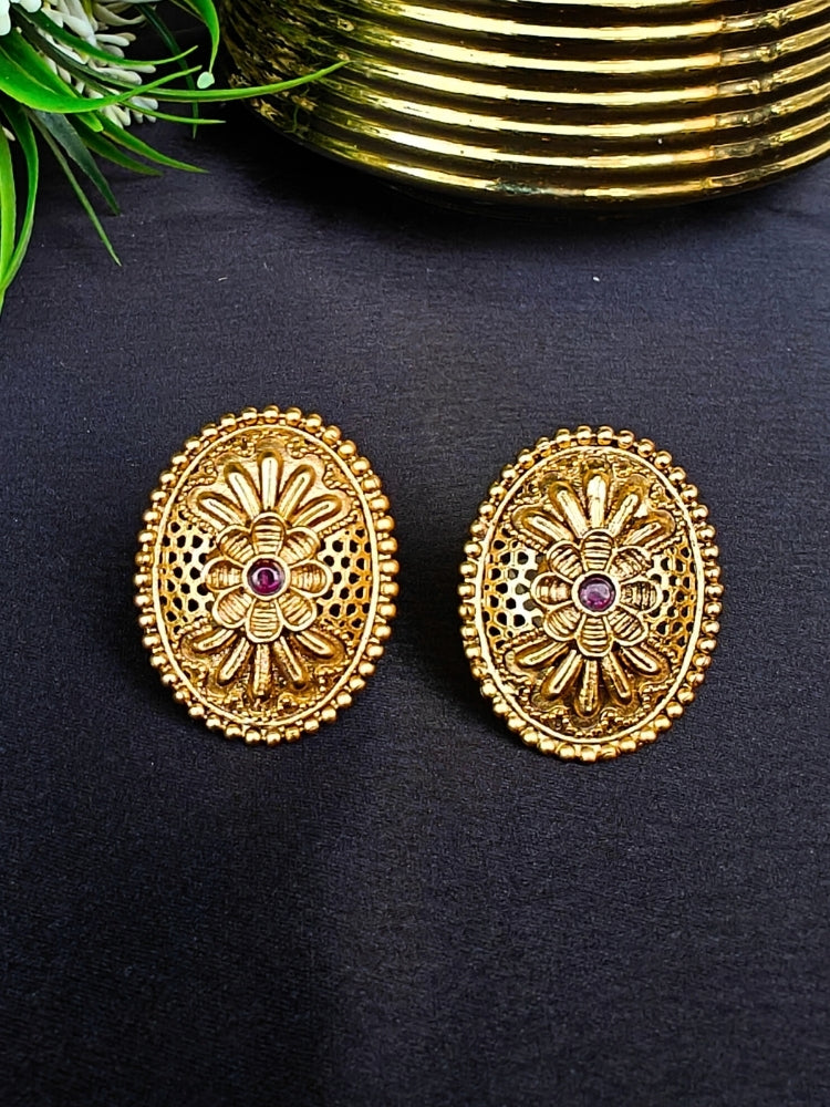 Close-up of an ornate traditional (Gold Polish) Studs Earrings with Filigree Work and Colored Stone. Festive Diwali outfit paired with a colorful Colored Stone Earrings. Festive celebration look enhanced with traditional Colored Stone Earrings.