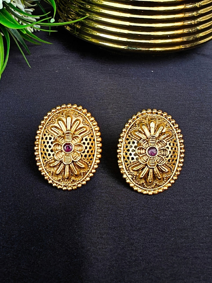 Close-up of an ornate traditional (Gold Polish) Studs Earrings with Filigree Work and Colored Stone. Festive Diwali outfit paired with a colorful Colored Stone Earrings. Festive celebration look enhanced with traditional Colored Stone Earrings.