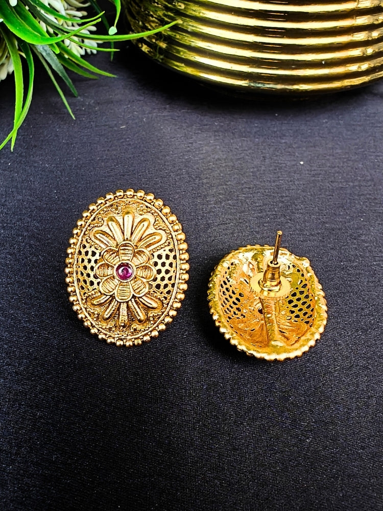 Close-up of an ornate traditional (Gold Polish) Studs Earrings with Filigree Work and Colored Stone. Festive Diwali outfit paired with a colorful Colored Stone Earrings. Festive celebration look enhanced with traditional Colored Stone Earrings.