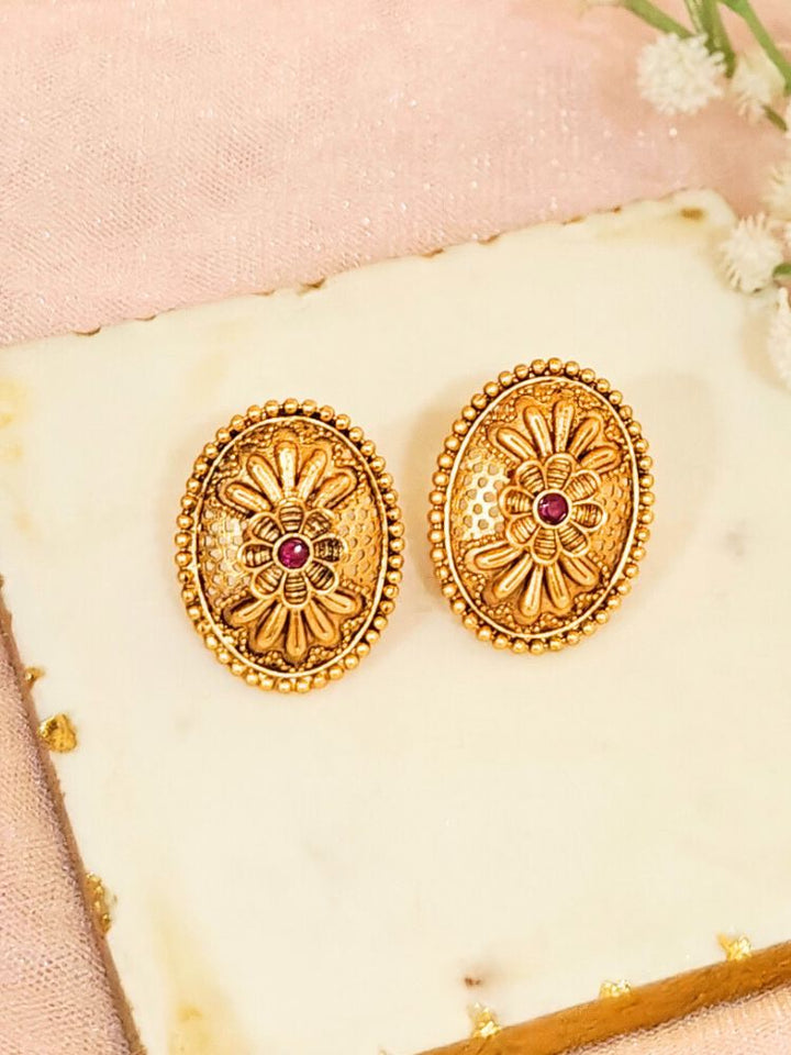 Close-up of an ornate traditional (Gold Polish) Studs Earrings with Filigree Work and Colored Stone. Festive Diwali outfit paired with a colorful Colored Stone Earrings. Festive celebration look enhanced with traditional Colored Stone Earrings.