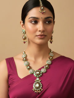 Close-up of a woman wearing an ornate traditional Red Jewelry Set, Earrings and Mangtikka with Kundan and Colored Stones. Bride wearing a traditional Kundan artificial necklace set for her wedding ceremony. Woman wearing trending Kundan artificial jewelry for wedding season in India.