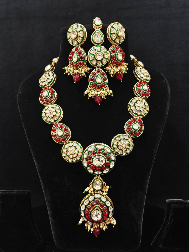Close-up of an ornate traditional Red Jewelry Set, Earrings and Mangtikka with Kundan and Colored Stones. Bride wearing a traditional Kundan artificial necklace set for her wedding ceremony. A trending Kundan artificial jewelry for wedding season in India.
