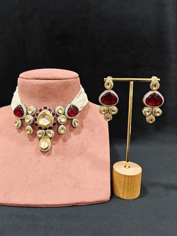 Close-up of a woman wearing an ornate traditional Red Collar Kundan jewellery set and earrings with American diamonds, Monalisa stone, Pearls, Kundan and Colored Stones. Festive Diwali outfit paired with a premium Kundan jewelry piece. Woman wearing trending Kundan artificial jewelry for wedding season in India.