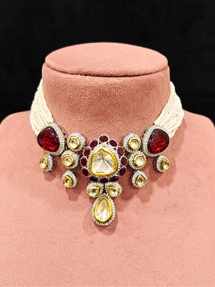 Close-up of a woman wearing an ornate traditional Red Collar Kundan jewellery set and earrings with American diamonds, Monalisa stone, Pearls, Kundan and Colored Stones. Festive Diwali outfit paired with a premium Kundan jewelry piece. Woman wearing trending Kundan artificial jewelry for wedding season in India.