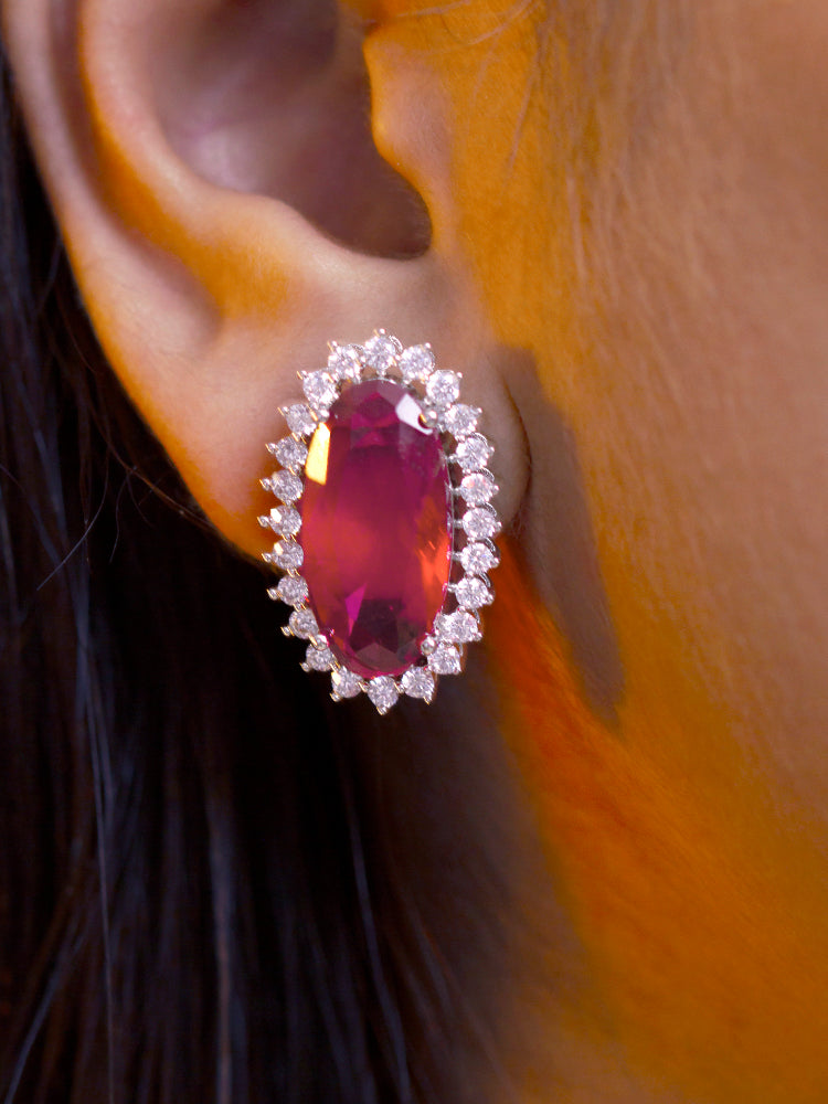 Close-up of a woman wearing an ornate Western (Silver Polish) Red Pendant set and Earrings with American Diamond and Red Colored Stone. Close-up of a cocktail party look featuring a premium Colored Stone Pendant Set. Party wear outfit completed with a lightweight Colored Stone Pendant set.