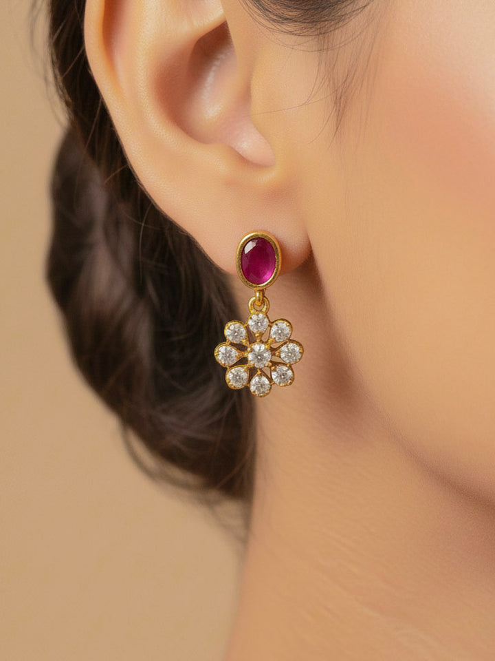 Close-up of a woman wearing an ornate traditional Diamond (gold Polish) Red & Green Collar jewellery set and earrings with American Diamond and Colored Stones. Mehendi function outfit styled with a lightweight American Diamond necklace. 