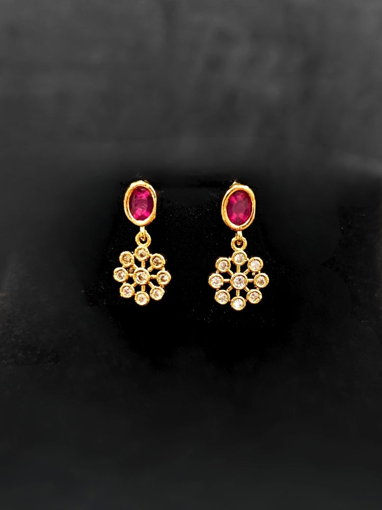 Close-up of an ornate traditional Diamond (gold Polish) Red & Green Collar jewellery set and earrings with American Diamond and Colored Stones. Mehendi function outfit styled with a lightweight American Diamond necklace. 