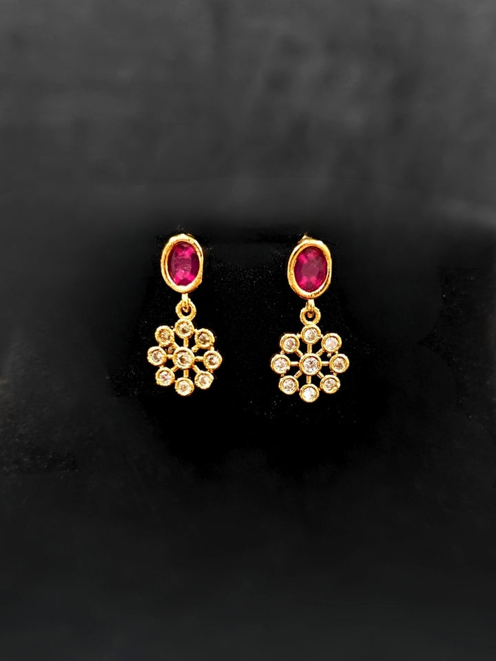 Close-up of an ornate traditional Diamond (gold Polish) Red & Green Collar jewellery set and earrings with American Diamond and Colored Stones. Mehendi function outfit styled with a lightweight American Diamond necklace. 