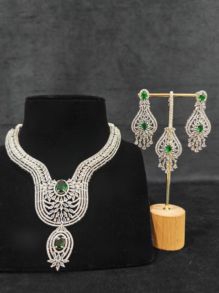 Close-up of an ornate Western Silver Diamond Collar jewellery set, earrings and Mangtikka with American Diamond and Green Color Stone. Bride-to-be styled in a premium American diamond artificial necklace for her reception party.
Close-up of a cocktail party look featuring a premium American diamond necklace.