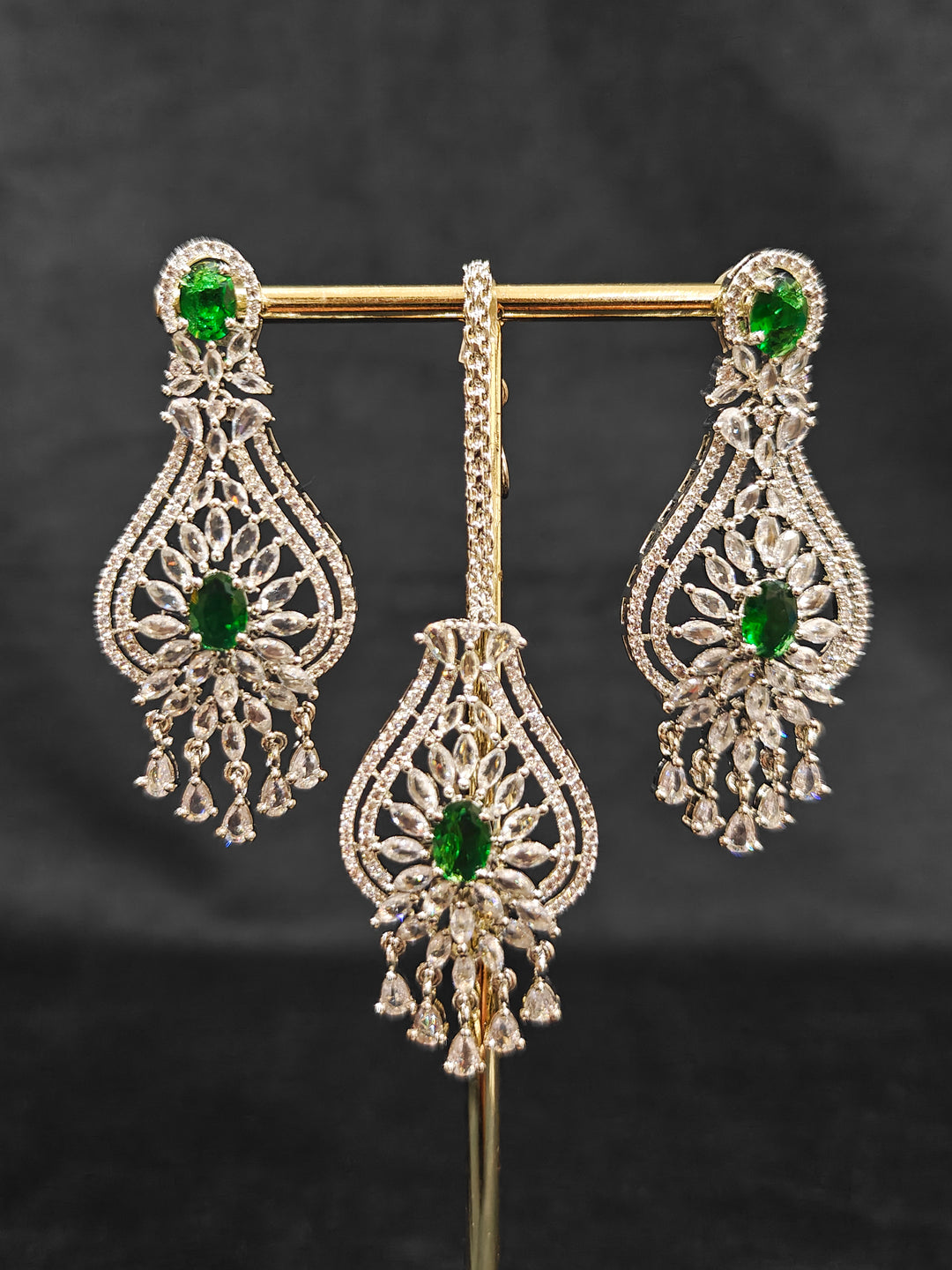 Close-up of an ornate Western Silver Diamond Collar jewellery set, earrings and Mangtikka with American Diamond and Green Color Stone. Bride-to-be styled in a premium American diamond artificial necklace for her reception party.
Close-up of a cocktail party look featuring a premium American diamond necklace.