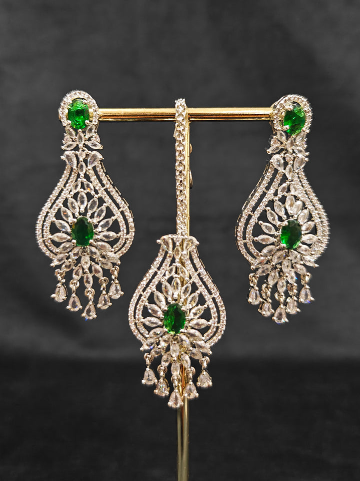 Close-up of an ornate Western Silver Diamond Collar jewellery set, earrings and Mangtikka with American Diamond and Green Color Stone. Bride-to-be styled in a premium American diamond artificial necklace for her reception party.
Close-up of a cocktail party look featuring a premium American diamond necklace.