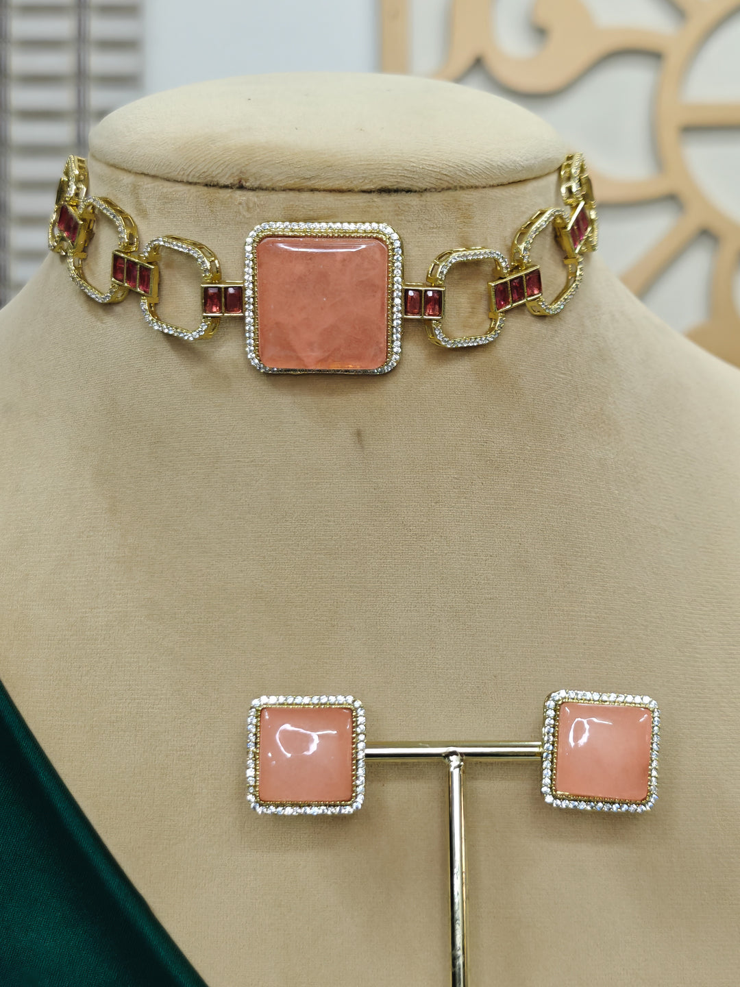 "A beautiful woman wearing an elegant artificial diamond and peach colored stone choker necklace and matching earrings. This premium artificial diamond jewelry set is perfect for special occasions, from Indian weddings to engagement parties, offering sophisticated glamour without the high price tag."
