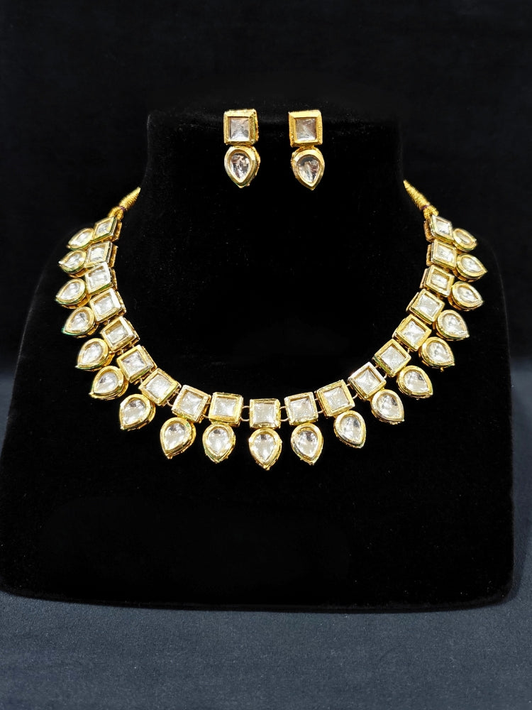 Close-up of an ornate traditional (Gold Polsih) Collar jewellery set and earrings with Kundan. Mehendi ceremony look completed with a handcrafted Kundan jewelry set. Festive saree styling with a premium artificial Kundan necklace. Perfect set for wedding functions and Festive.