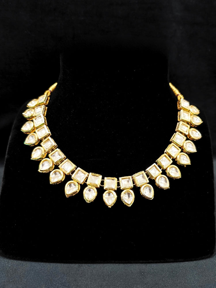 Close-up of an ornate traditional (Gold Polsih) Collar jewellery set and earrings with Kundan. Mehendi ceremony look completed with a handcrafted Kundan jewelry set. Festive saree styling with a premium artificial Kundan necklace. Perfect set for wedding functions and Festive.
