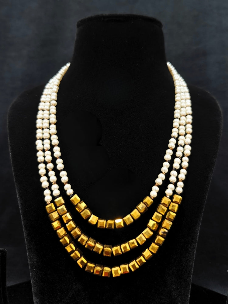 Close-up of an ornate Indo-Western White and Gold Pearl Layered Jewellery set and Earring with Pearls and American Diamond. Festive celebration look enhanced with traditional Pearl jewelry. Close-up of enamel work in Meenakari artificial Pearl jewelry.