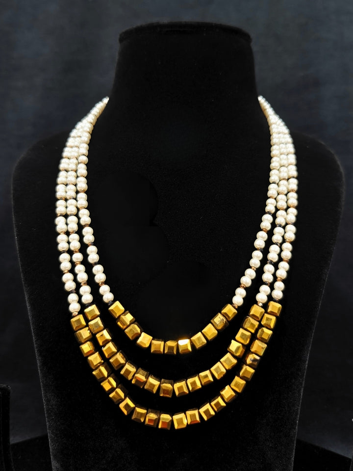 Close-up of an ornate Indo-Western White and Gold Pearl Layered Jewellery set and Earring with Pearls and American Diamond. Festive celebration look enhanced with traditional Pearl jewelry. Close-up of enamel work in Meenakari artificial Pearl jewelry.
