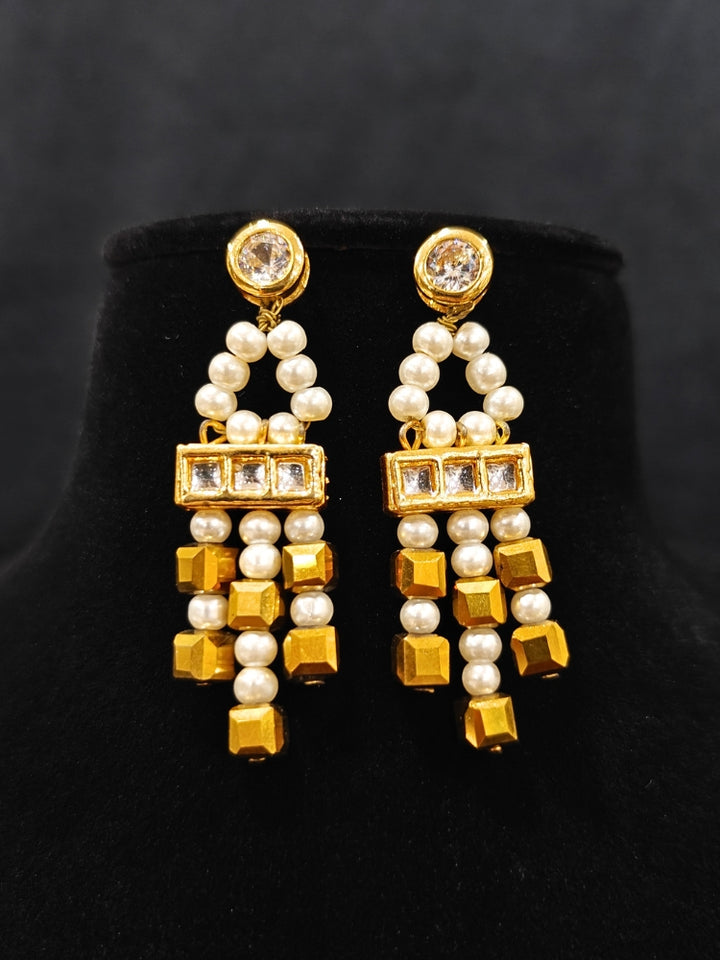 Close-up of an ornate Indo-Western White and Gold Pearl Layered Jewellery set and Earring with Pearls and American Diamond. Festive celebration look enhanced with traditional Pearl jewelry. Close-up of enamel work in Meenakari artificial Pearl jewelry.