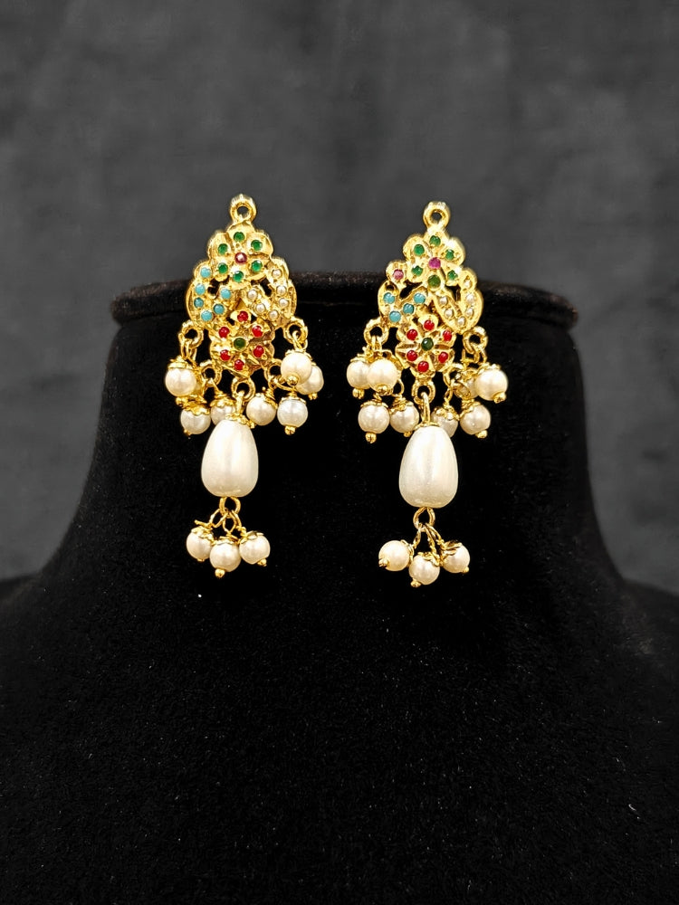 Close-up of an ornate traditional (Gold Polish) Multi-Color Pendant Set and Earrings with  Pearl and Colored Stones. Festive saree look completed with a handcrafted Jadau Pendant. Close-up of high-quality Jadau artificial Pendant craftsmanship.