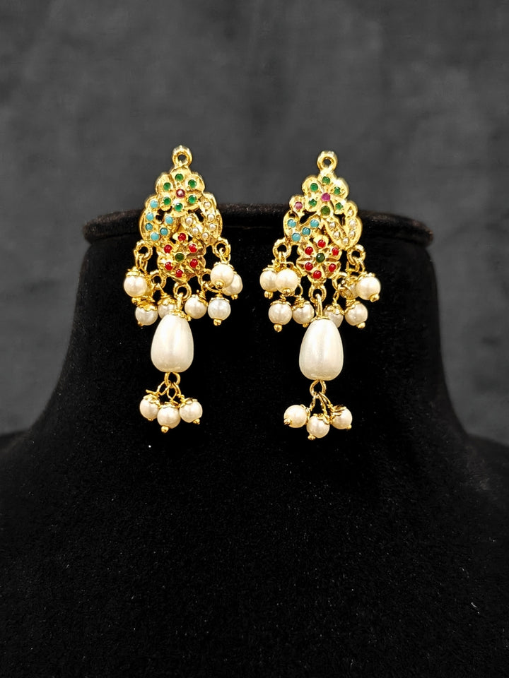 Close-up of an ornate traditional (Gold Polish) Multi-Color Pendant Set and Earrings with  Pearl and Colored Stones. Festive saree look completed with a handcrafted Jadau Pendant. Close-up of high-quality Jadau artificial Pendant craftsmanship.