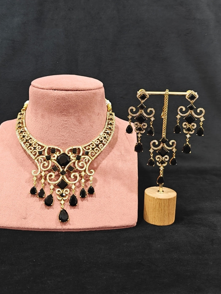 A glamorous artificial diamond necklace with black colored stone paired with chic earrings and maangtikka, perfect for bridal wear. This high-quality artificial diamond jewelry set is the ideal choice for modern brides looking for a budget-friendly option with timeless sparkle."