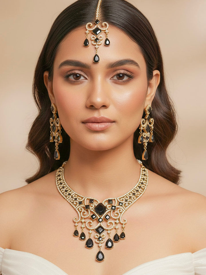 "A stunning woman wearing a glamorous artificial diamond necklace with black colored stone paired with chic earrings and maangtikka, perfect for bridal wear. This high-quality artificial diamond jewelry set is the ideal choice for modern brides looking for a budget-friendly option with timeless sparkle."