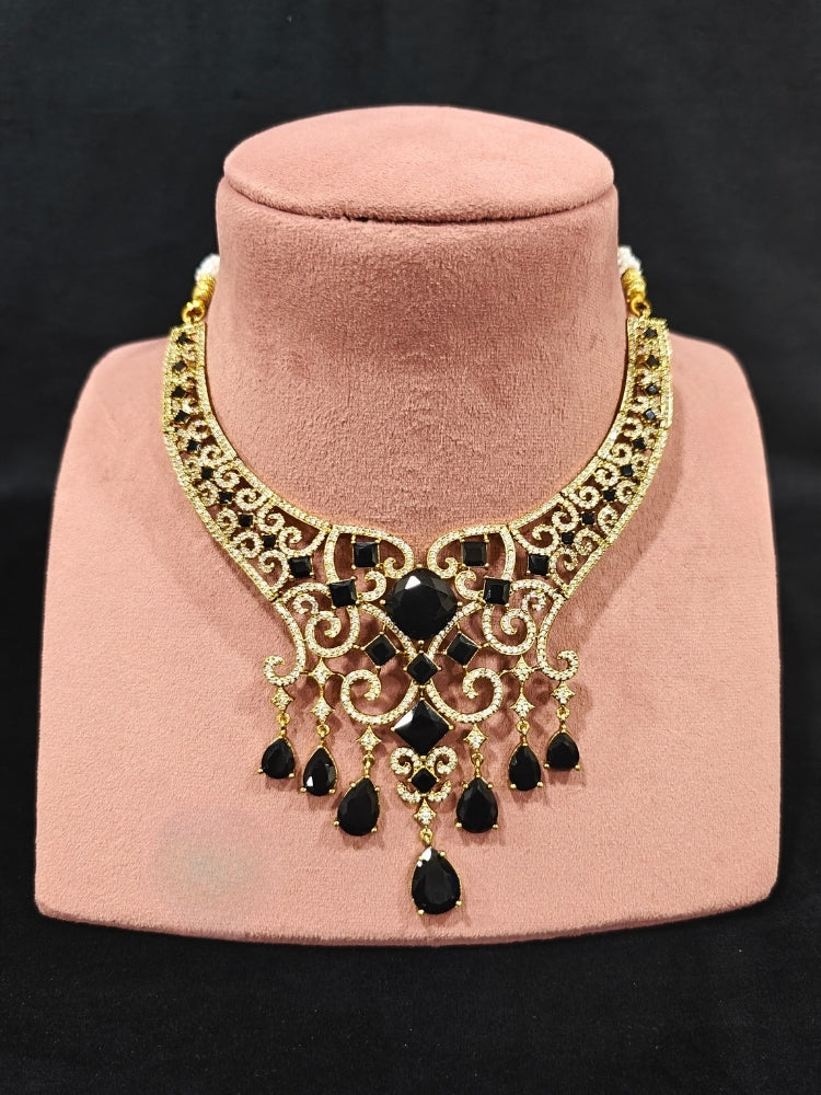 A glamorous artificial diamond necklace with black colored stone paired with chic earrings and maangtikka, perfect for bridal wear. This high-quality artificial diamond jewelry set is the ideal choice for modern brides looking for a budget-friendly option with timeless sparkle."