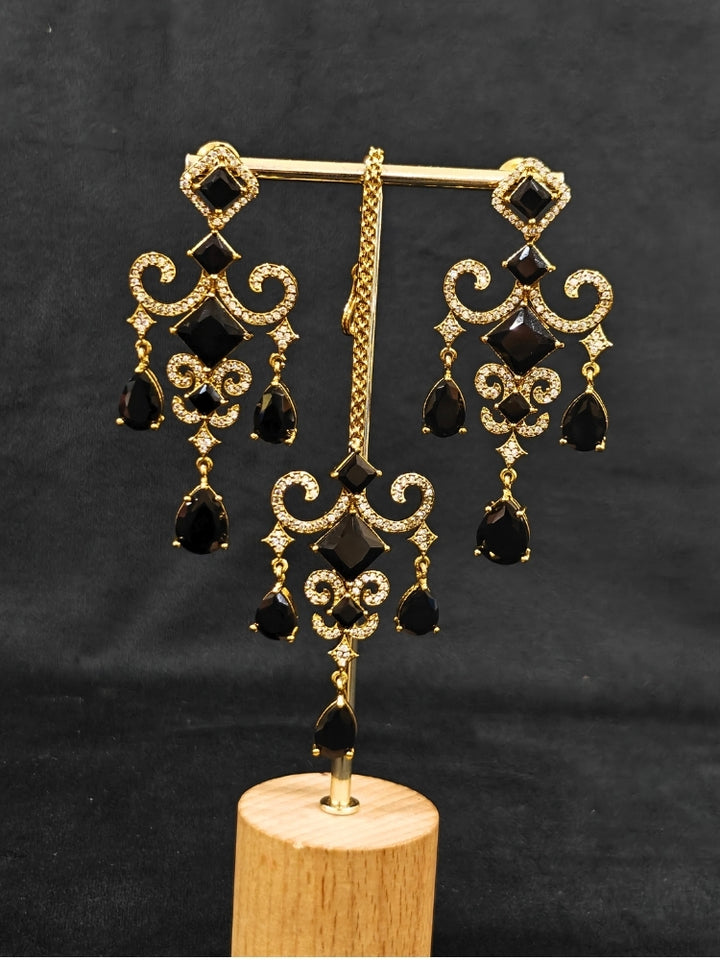 A glamorous artificial diamond necklace with black colored stone paired with chic earrings and maangtikka, perfect for bridal wear. This high-quality artificial diamond jewelry set is the ideal choice for modern brides looking for a budget-friendly option with timeless sparkle."