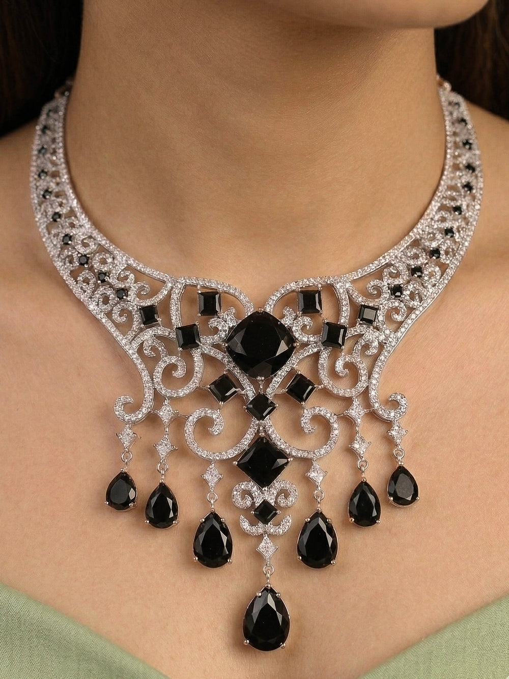 Close-up of a woman wearing an ornate Black Indo-Western Diamond Silver Collar jewellery set and earrings and maangtikka with American Diamond and Black Colored Stones. Bride-to-be styled in a premium American diamond artificial necklace for her reception party. Elegant wedding jewelry look featuring a premium artificial American diamond necklace.