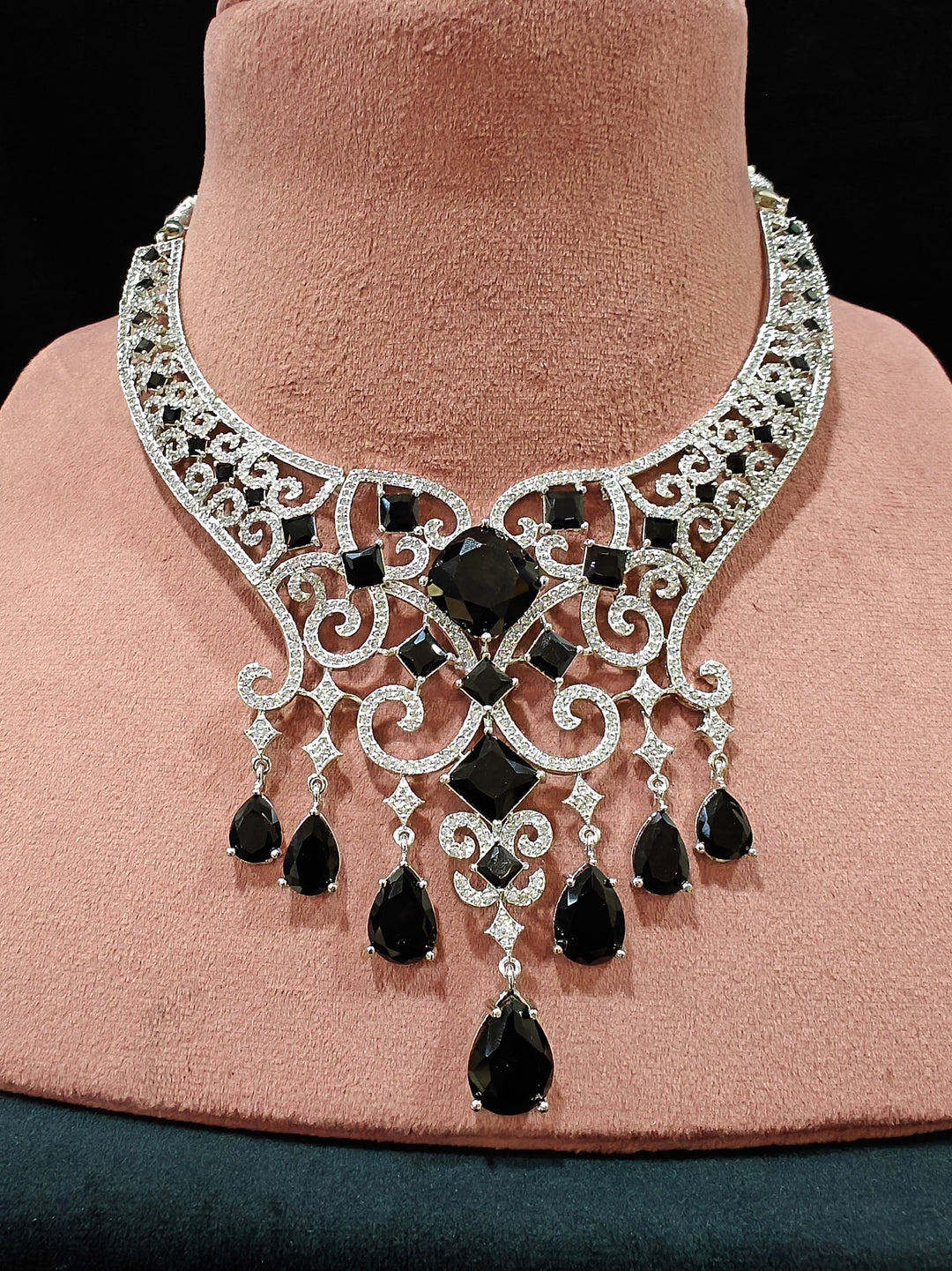 Close-up of an ornate Black Indo-Western Diamond Silver Collar jewellery set and earrings and maangtikka with American Diamond and Black Colored Stones. Bride-to-be styled in a premium American diamond artificial necklace for her reception party. Elegant wedding jewelry look featuring a premium artificial American diamond necklace.