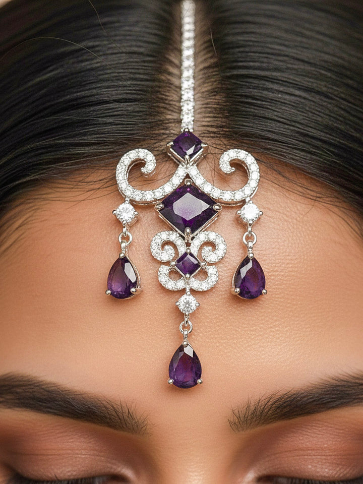 Close-up of a woman wearing an ornate Indo-Western American Diamond Silver Collar jewellery set and earrings and maangtikka with American Diamond and Purple Colored Stones. Bride-to-be styled in a premium American diamond artificial necklace for her reception party. Elegant wedding jewelry look featuring a premium artificial American diamond necklace.