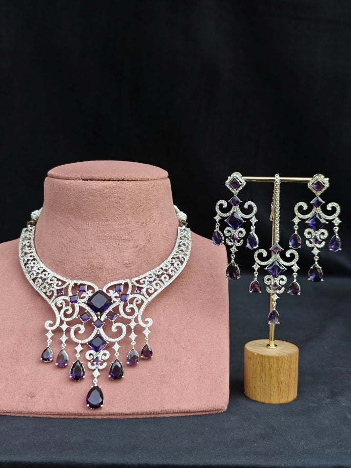 Close-up of an ornate Indo-Western American Diamond Silver Collar jewellery set and earrings and maangtikka with American Diamond and Purple Colored Stones. Bride-to-be styled in a premium American diamond artificial necklace for her reception party. Elegant wedding jewelry look featuring a premium artificial American diamond necklace.