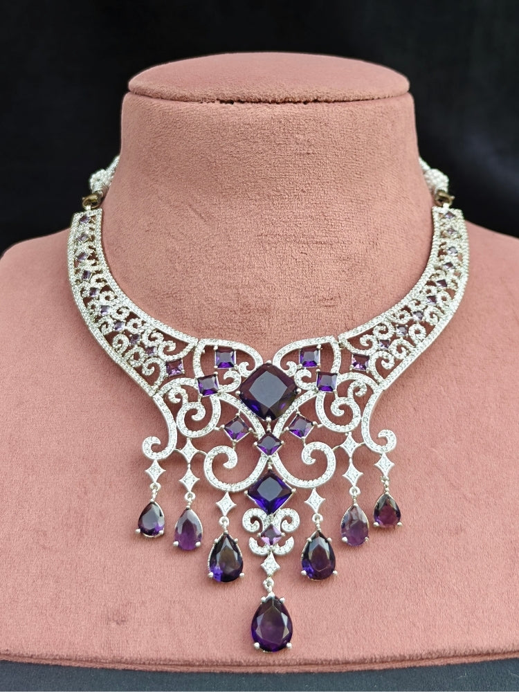Close-up of an ornate Indo-Western American Diamond Silver Collar jewellery set and earrings and maangtikka with American Diamond and Purple Colored Stones. Bride-to-be styled in a premium American diamond artificial necklace for her reception party. Elegant wedding jewelry look featuring a premium artificial American diamond necklace.