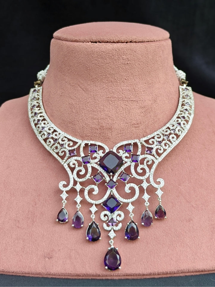 Close-up of an ornate Indo-Western American Diamond Silver Collar jewellery set and earrings and maangtikka with American Diamond and Purple Colored Stones. Bride-to-be styled in a premium American diamond artificial necklace for her reception party. Elegant wedding jewelry look featuring a premium artificial American diamond necklace.