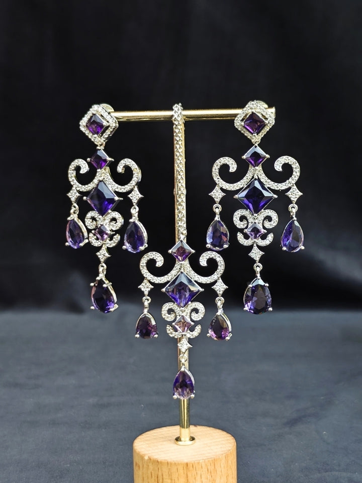 Close-up of an ornate Indo-Western American Diamond Silver Collar jewellery set and earrings and maangtikka with American Diamond and Purple Colored Stones. Bride-to-be styled in a premium American diamond artificial necklace for her reception party. Elegant wedding jewelry look featuring a premium artificial American diamond necklace.