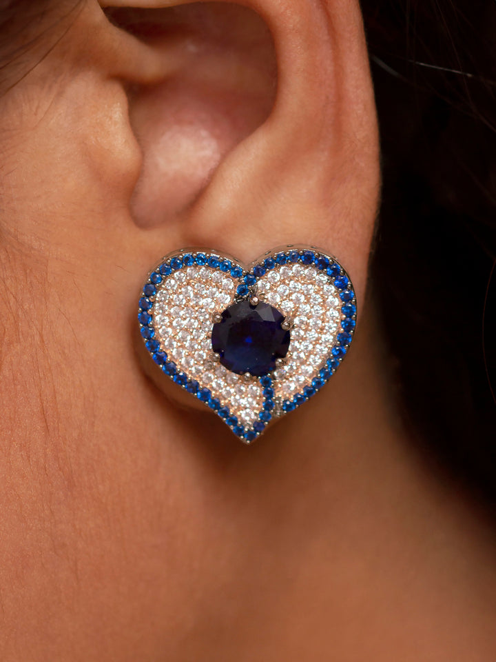 Close-up of a woman wearing an ornate Western Blue (Black Polish Victorian Finish) Pendant set and earrings with American Diamond and Blue Colored Stones. Close-up shot of a high-quality American diamond artificial Pendant worn for festive celebrations. Party wear outfit completed with a lightweight American diamond Pendant.
