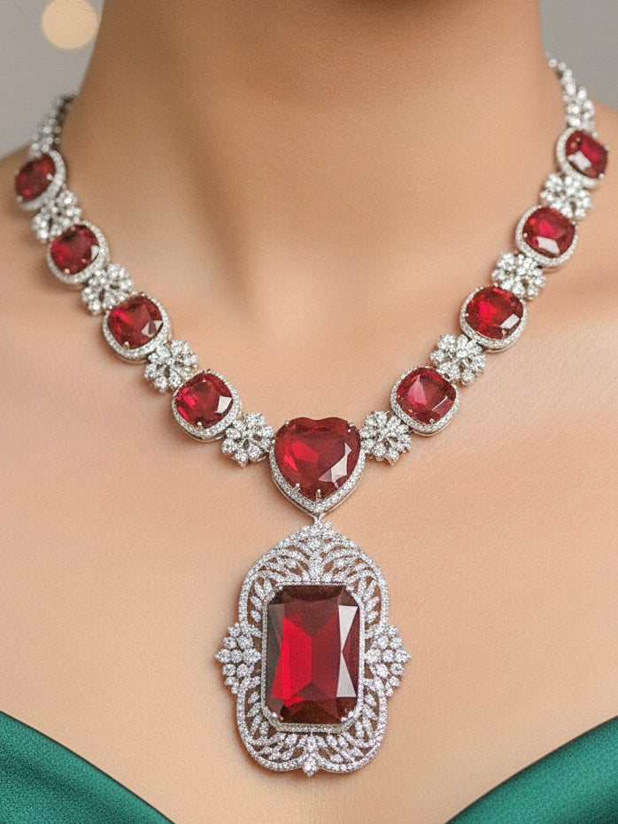 Close-up of a woman wearing an ornate Western (Silver Polish) Red Collar Jewellery Set and Earrings with American Diamond and Red Colored Stones. Party wear outfit completed with a lightweight Colored Stone necklace. Close-up of a cocktail party look featuring a premium Colored Stone necklace.
