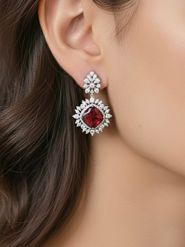 Close-up of a woman wearing an ornate Western (Silver Polish) Red Collar Jewellery Set and Earrings with American Diamond and Red Colored Stones. Party wear outfit completed with a lightweight Colored Stone necklace. Close-up of a cocktail party look featuring a premium Colored Stone necklace.