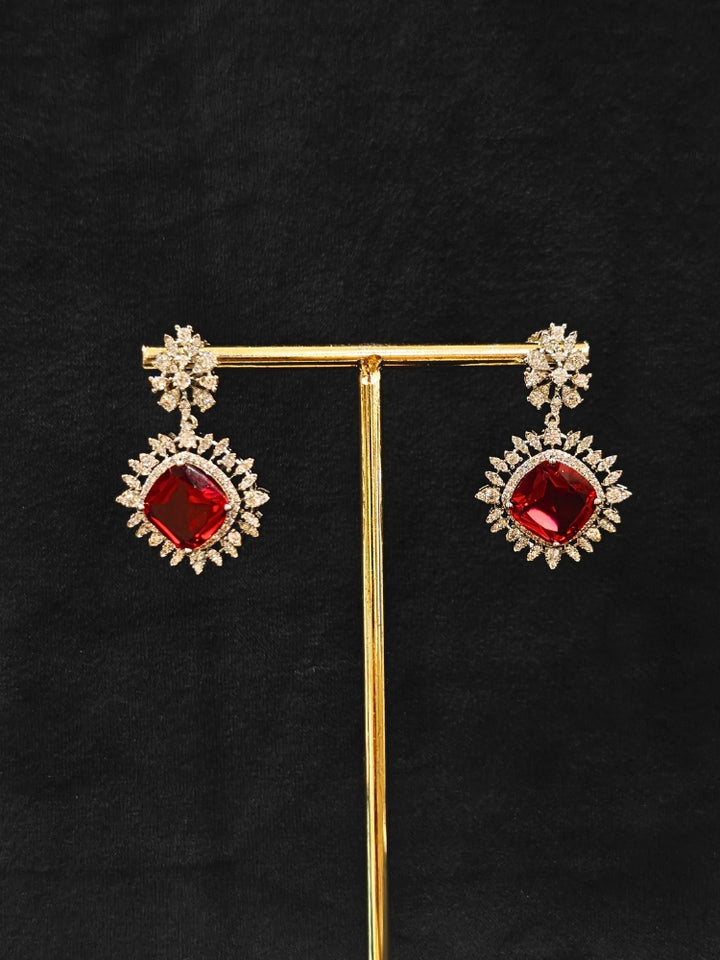Close-up of an ornate Western (Silver Polish) Red Collar Jewellery Set and Earrings with American Diamond and Red Colored Stones. Party wear outfit completed with a lightweight Colored Stone necklace. Close-up of a cocktail party look featuring a premium Colored Stone necklace.