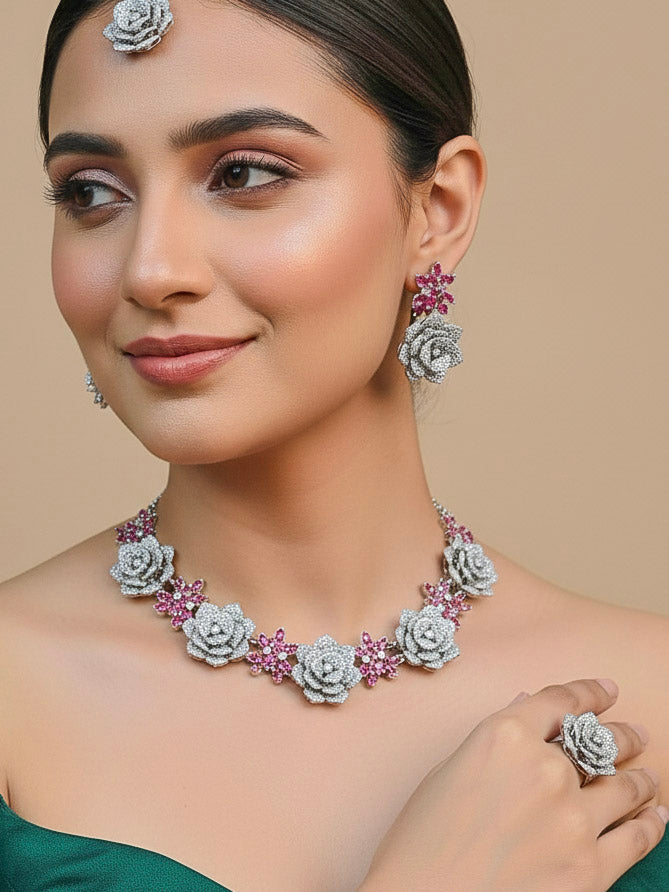 Close-up of a woman wearing an ornate  Indo-western Pink Silver Collar American Diamond jewellery set, earrings, maangtikka, Ring and Bracelet with Pink Colored Stones and American Diamond. Woman styling a statement American diamond necklace with an off-shoulder gown for a reception. A graceful woman wearing a trending American diamond necklace for a 2026 wedding celebration.