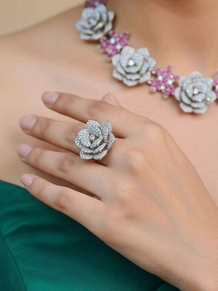Close-up of a woman wearing an ornate  Indo-western Pink Silver Collar American Diamond jewellery set, earrings, maangtikka, Ring and Bracelet with Pink Colored Stones and American Diamond. Woman styling a statement American diamond necklace with an off-shoulder gown for a reception. A graceful woman wearing a trending American diamond necklace for a 2026 wedding celebration.