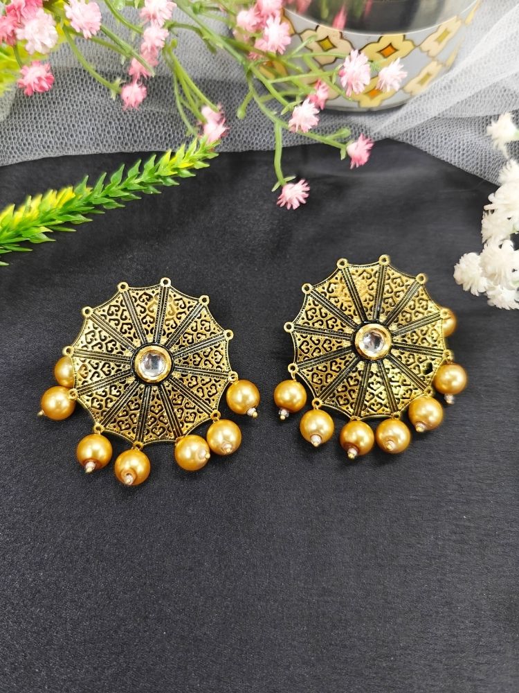 Roshni Earrings—large, ornate gold earrings featuring intricate filigree design, dangling Pearls. The circular design covers most of her earlobe, perfect for wedding ceremony attire, shown on a black background. 