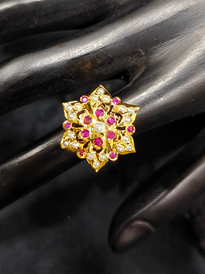 Close-up of an ornate traditional Ruby Pink and White jadau gold Bracelet with matched Ring with pearls and Colored stone. Festive outfit paired with a premium imitation Jadau bracelet with Ring in India. Close-up of a high-quality imitation Jadau bracelet with Ring for festive wear.