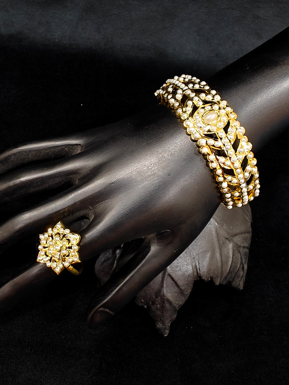 Close-up of an ornate traditional White jadau gold Bracelet with matched Ring with pearls. Festive outfit paired with a premium imitation Jadau bracelet with Ring in India. Close-up of a high-quality imitation Jadau bracelet with Ring for festive wear.