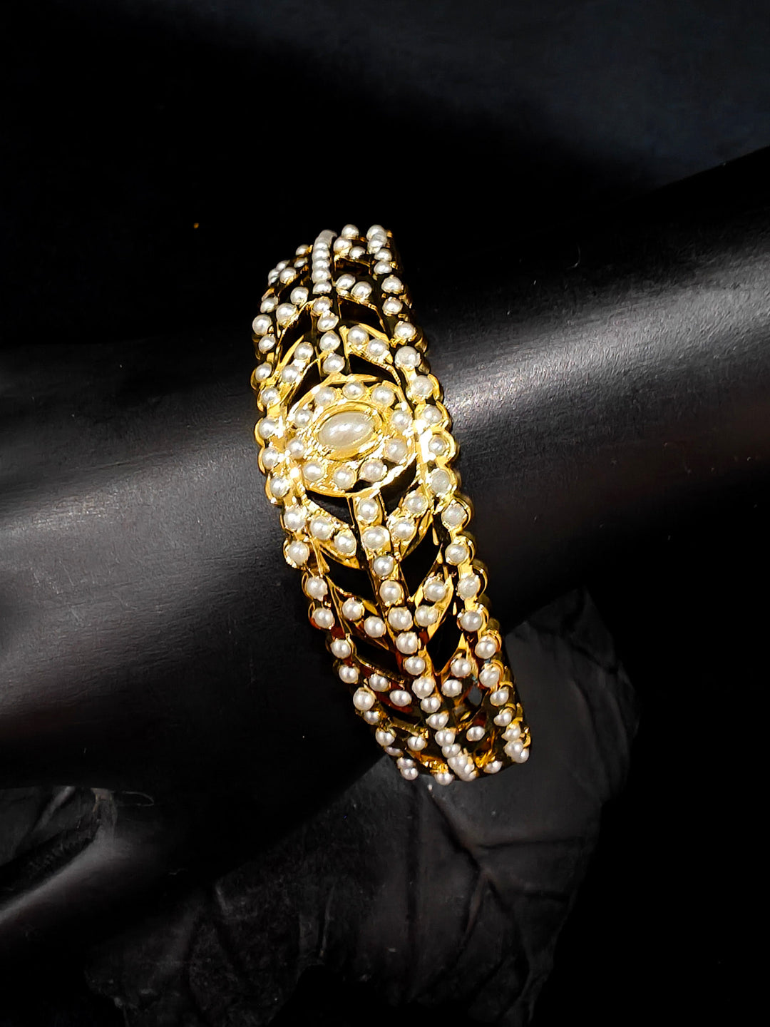 Close-up of an ornate traditional White jadau gold Bracelet with matched Ring with pearls. Festive outfit paired with a premium imitation Jadau bracelet with Ring in India. Close-up of a high-quality imitation Jadau bracelet with Ring for festive wear.