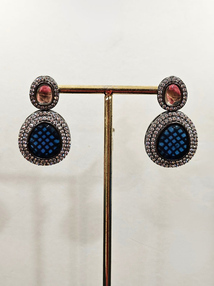 Close-up of an ornate Indo-western American Diamond Royal Blue Collar jewellery set and earrings with American Diamonds and Monalisa Stones. Woman styling a statement American diamond necklace with an off-shoulder gown for a reception. Close-up of a luxury American Diamond imitation necklace styled.