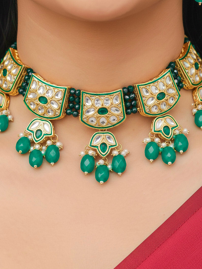 Close-up of a woman wearing an ornate traditional (Gold Polish) Dark Green Choker jewellery set and earrings with Pearl, Crystal stones, Kundan, Colored Stones and Tumble Beads. Mehendi ceremony look completed with a handcrafted Kundan jewelry set. Wedding celebration look enhanced with a statement Kundan necklace.