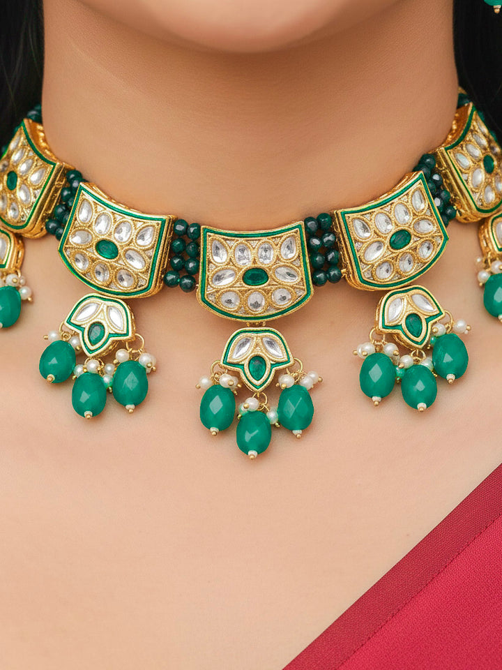 Close-up of a woman wearing an ornate traditional (Gold Polish) Dark Green Choker jewellery set and earrings with Pearl, Crystal stones, Kundan, Colored Stones and Tumble Beads. Mehendi ceremony look completed with a handcrafted Kundan jewelry set. Wedding celebration look enhanced with a statement Kundan necklace.