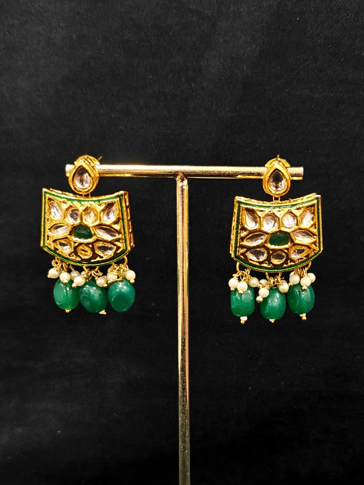 Close-up of an ornate traditional (Gold Polish) Dark Green Choker jewellery set and earrings with Pearl, Crystal stones, Kundan, Colored Stones and Tumble Beads. Mehendi ceremony look completed with a handcrafted Kundan jewelry set. Wedding celebration look enhanced with a statement Kundan necklace.