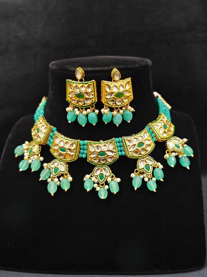 Close-up of an ornate traditional (Gold Polish) Mint Green Choker jewellery set and earrings with Pearl, Crystal stones, Kundan, Colored Stones and Tumble Beads. Mehendi ceremony look completed with a handcrafted Kundan jewelry set. Wedding celebration look enhanced with a statement Kundan necklace.